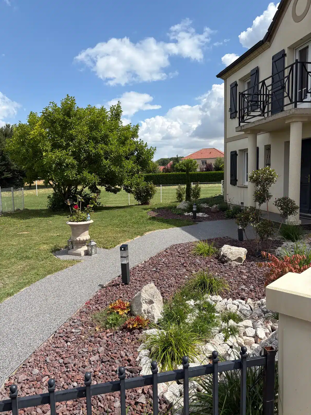 Allée de jardin en moquette de pierre grise menant à la maison à Dainville
