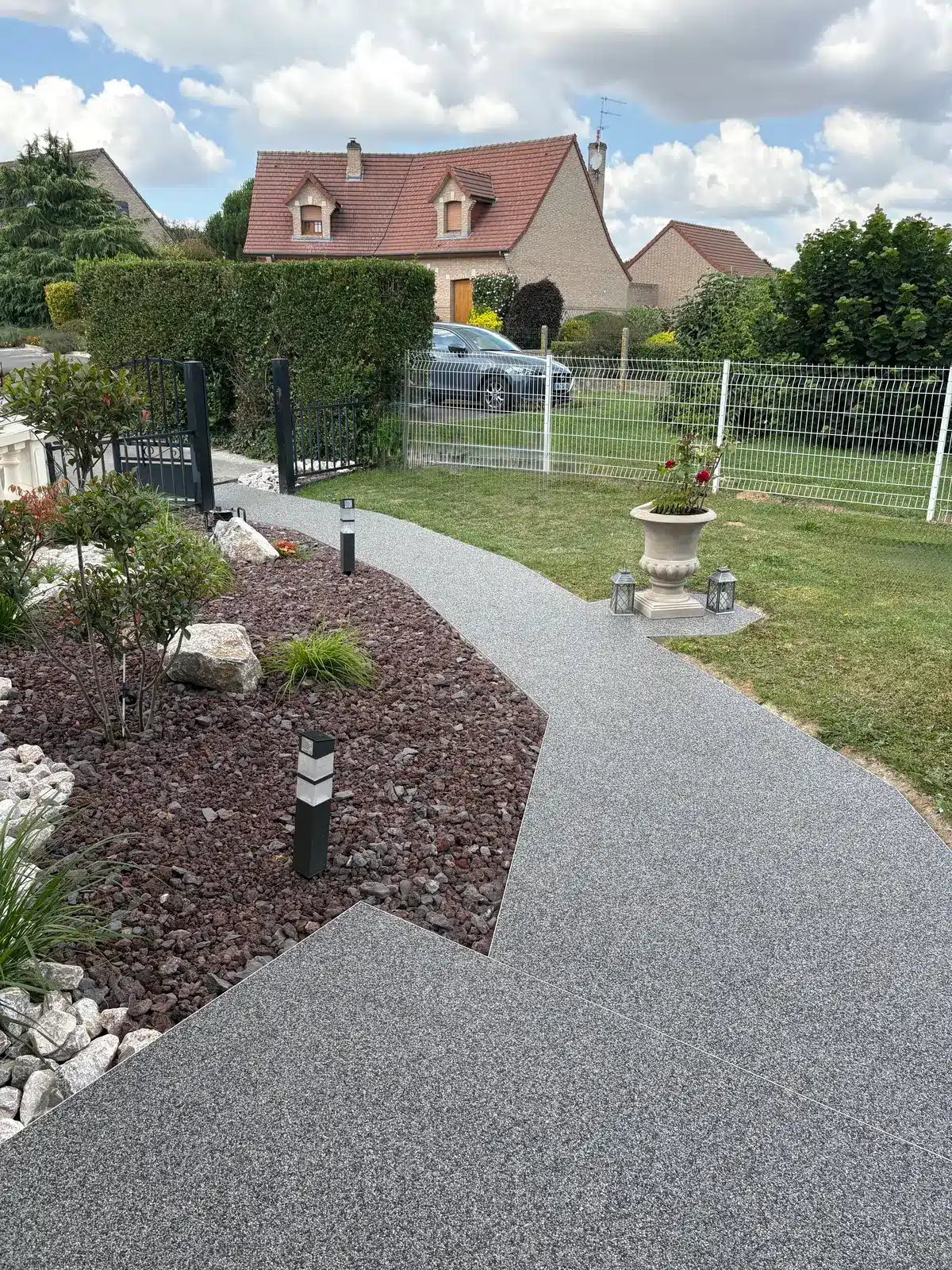 Allée sinueuse en moquette de pierre vers le portail à Dainville