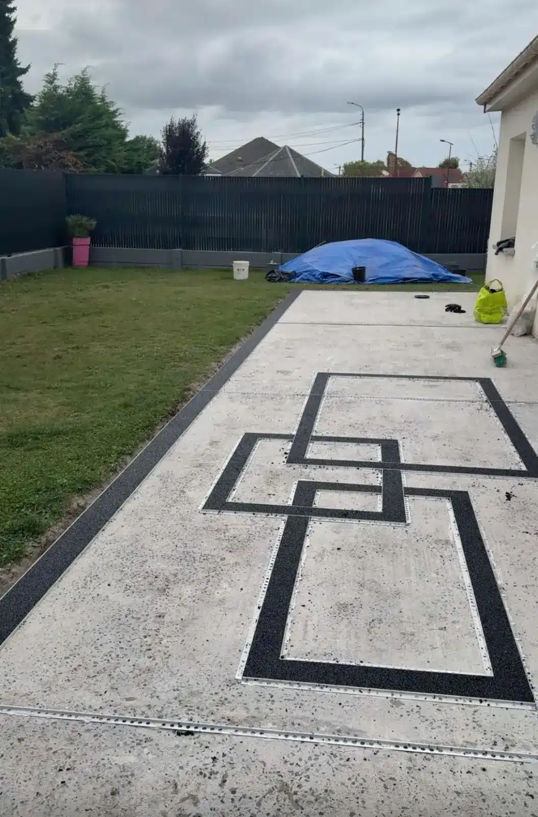 Mise en place des bandes noires du motif géométrique sur la terrasse à Méricourt